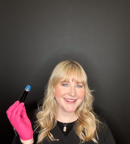 Staff Portrait of Chloe Stauffer. She is smiling and holding a Hydrafacial pen.